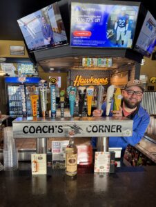 One of Coach's Corner's bartenders peeking out from behind the beer taps