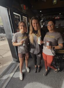 3 of the Coach's Corner staff by the open garage door to the patio