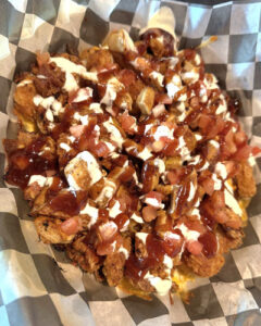 Coach's Corner C.B.B.R. loaded tater tots covered in grilled chicken, shredded cheese, homemade bacon crumbles, tomatoes, ranch, and bbq sauce