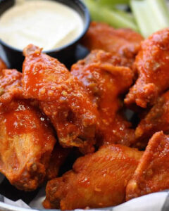 Coach's Corner jumbo wings coated in hot sauce served with ranch